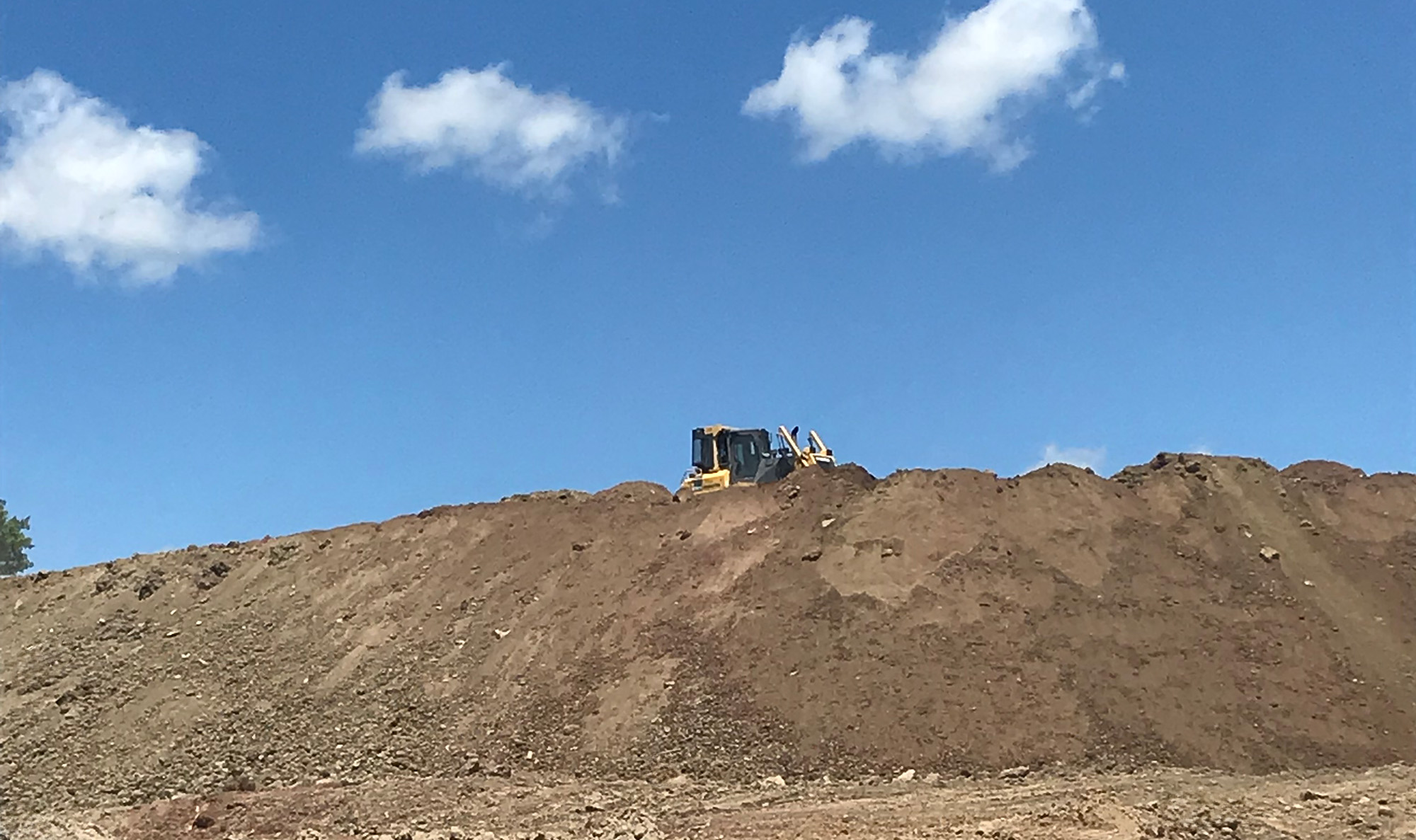 An Ashgrove clean fill site being managed with an excavator